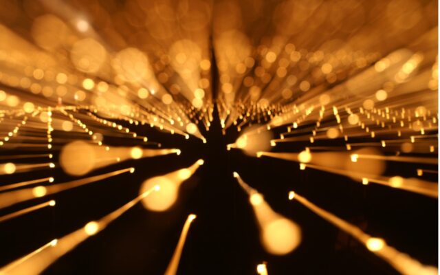 Digital image of gold color particles of light in motion.