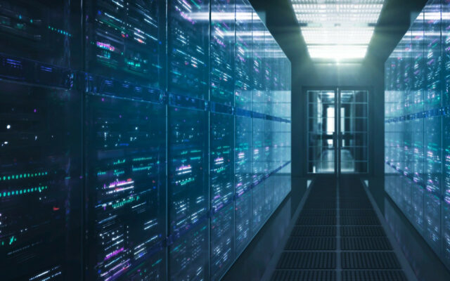 Row of servers inside closed section of data center, with view from hallway towards door in the background.