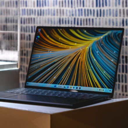 Dell Latitude 9440 laptop with image on the display on a stand in front of a brick wall.