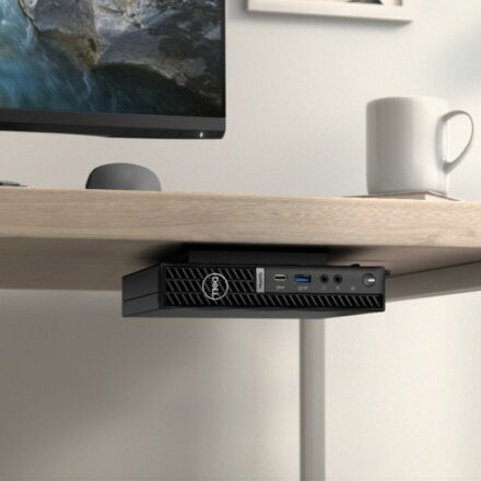 Dell OptiPlex Small Form Factor Plus 7010, secured to underside of a desk. a Dell monitor and mouse are on desk's surface with a white coffee mug nearby.