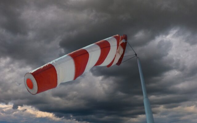 Windsock, orange and white striped, indicating strength of wind strength before an approaching storm, which is appearing in the background.