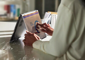 Woman reviewing data on Dell APEX platform on a Dell Latitude 9430 2-in-1 laptop.