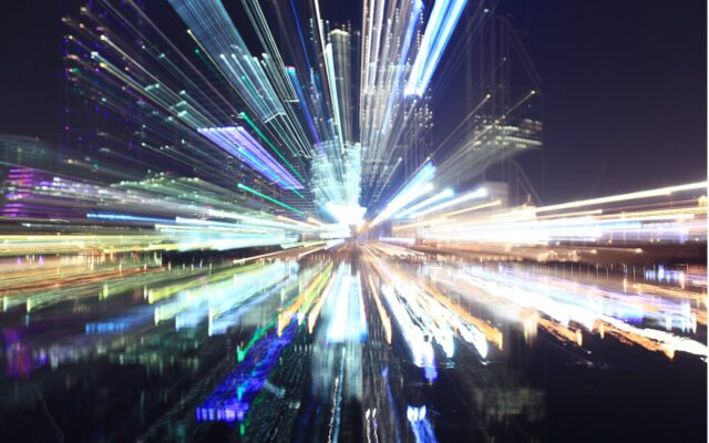 Unfocused image of a city's downtown area at night, with building and city lights radiating outward.