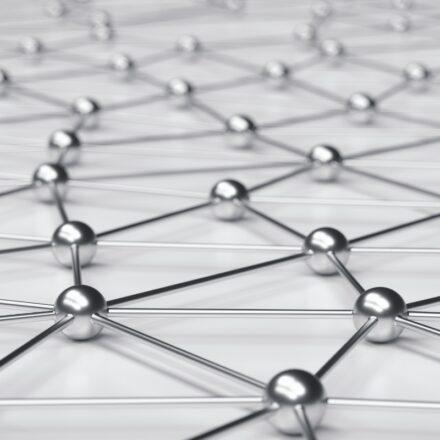 Metallic spheres connected on an off-white surface.
