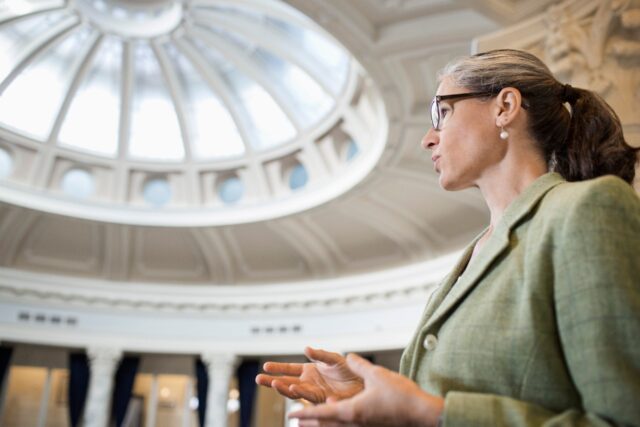 Caucasian politician talking in government building.
