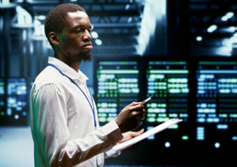 IT programmer using clipboard to assess supercomputer cybersecurity dangers arising due to unsecured network connections. Supervisor making sure high tech facility is invulnerable to malware attacks