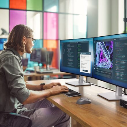 Professional working on a laptop in a modern office, representing AI powered PCs for workplace productivity with innovation and collaboration tools.